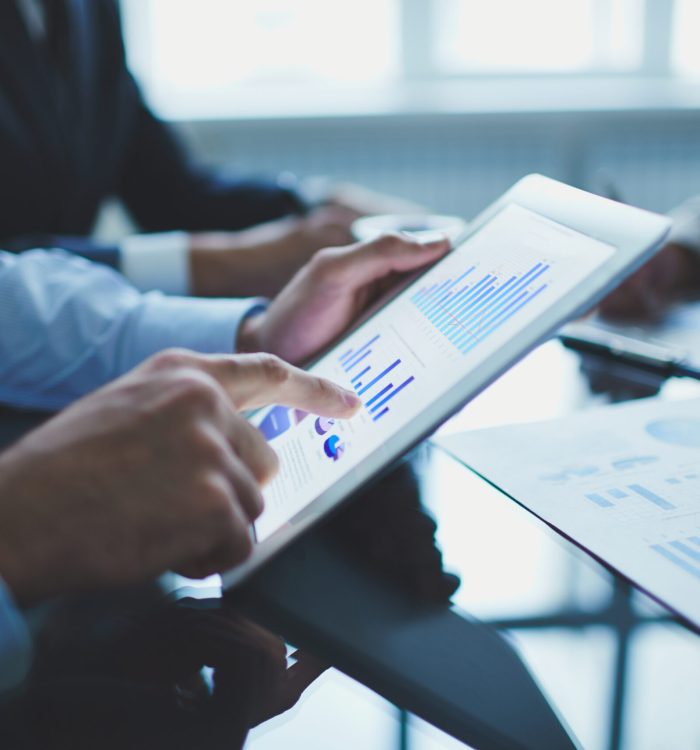 Image of businessperson pointing at document in touchpad at meeting